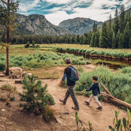 man and boy walking along path with view of moutain