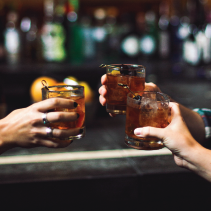 Toasting drinks at a bar