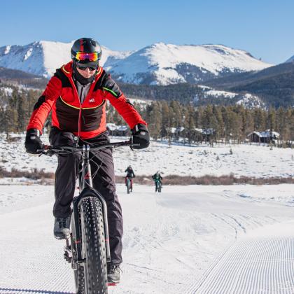 A man fat bikes through a snow-covered trail