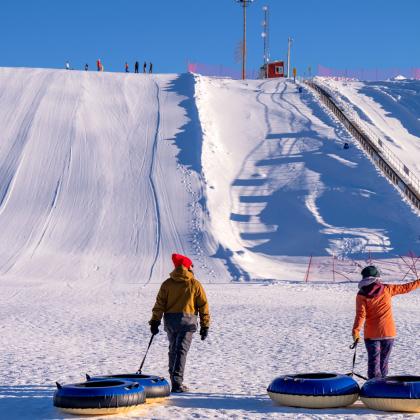  A couple walking towards a tubing hill