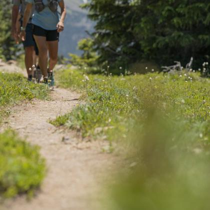 A hiking trail with hiker's feet in the distance