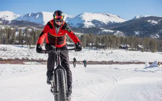 A man fat bikes through a snow-covered trail