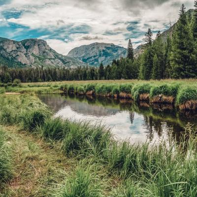 River surrounded by grass with view of mountains