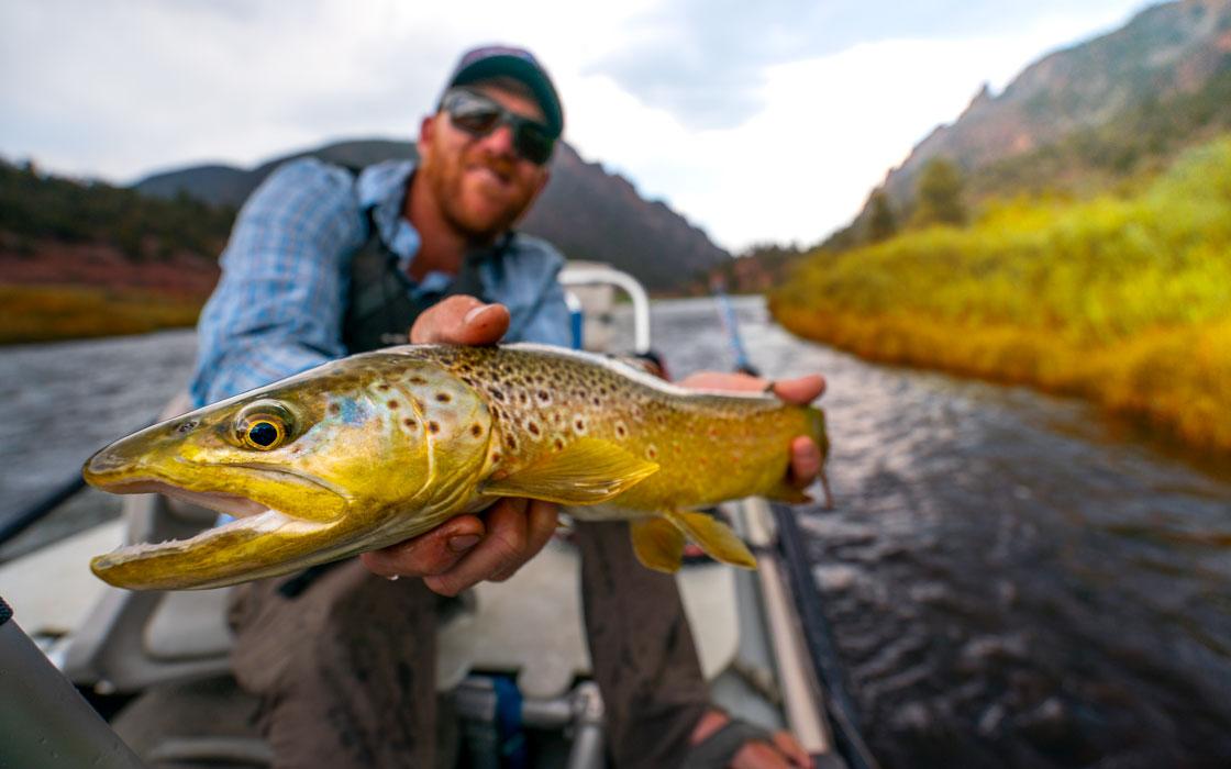Man holds up a fish he just caught for the camera