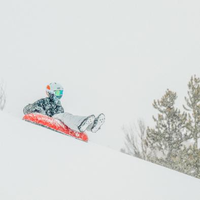 boy tubing down a snowy hill