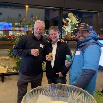 three men holding drinks in jackets