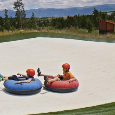 two kids on tubes going down the mountain