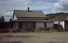 Find Cozens Ranch Museum along Hwy 40 -- a white with green historic building. Photo