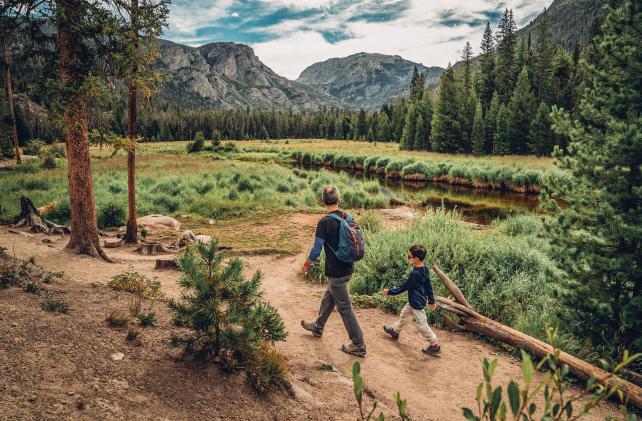 man and boy walking along path with view of moutain
