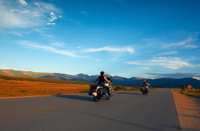 Motorcycles on the open road with blue sky.