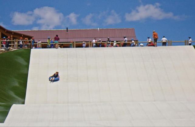 Kids going down summer tubbing hill