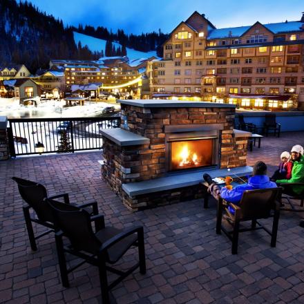Family sits fireside at Winter Park Resort in Winter Park, Colorado 